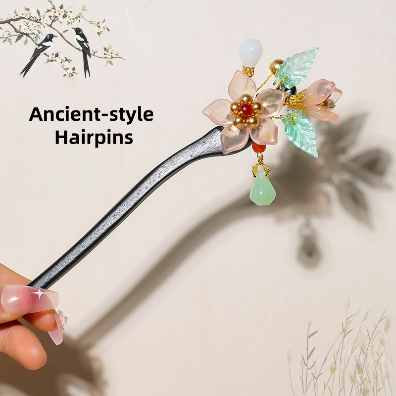 Ancient-style hairpin with floral design held by a hand against a neutral background